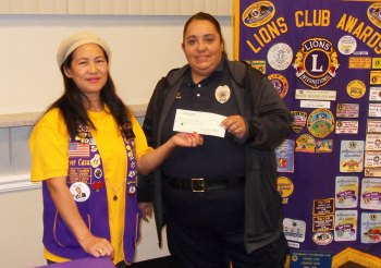Lions Club President Ever Casas presents a check for $250 to Community Services Officer Soledad Perez for the police department's "Reason for the Season" program.